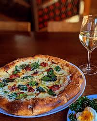 Eatery A signature dishes Wood-Fired Pizzas (e.g., Spicy Soppressata, Margherita), Lamb Spiedini, Hummus with Wood-Fired Pita, various handmade pastas, Moroccan Chicken.